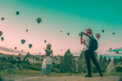 People taking pictures of hot air balloons